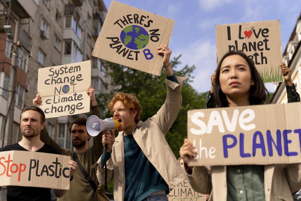 A group of passionate climate activists protesting on the road, holding banners and placards demanding sustainability and urgent climate action, with a backdrop of urban buildings and green signs calling for a cleaner planet.