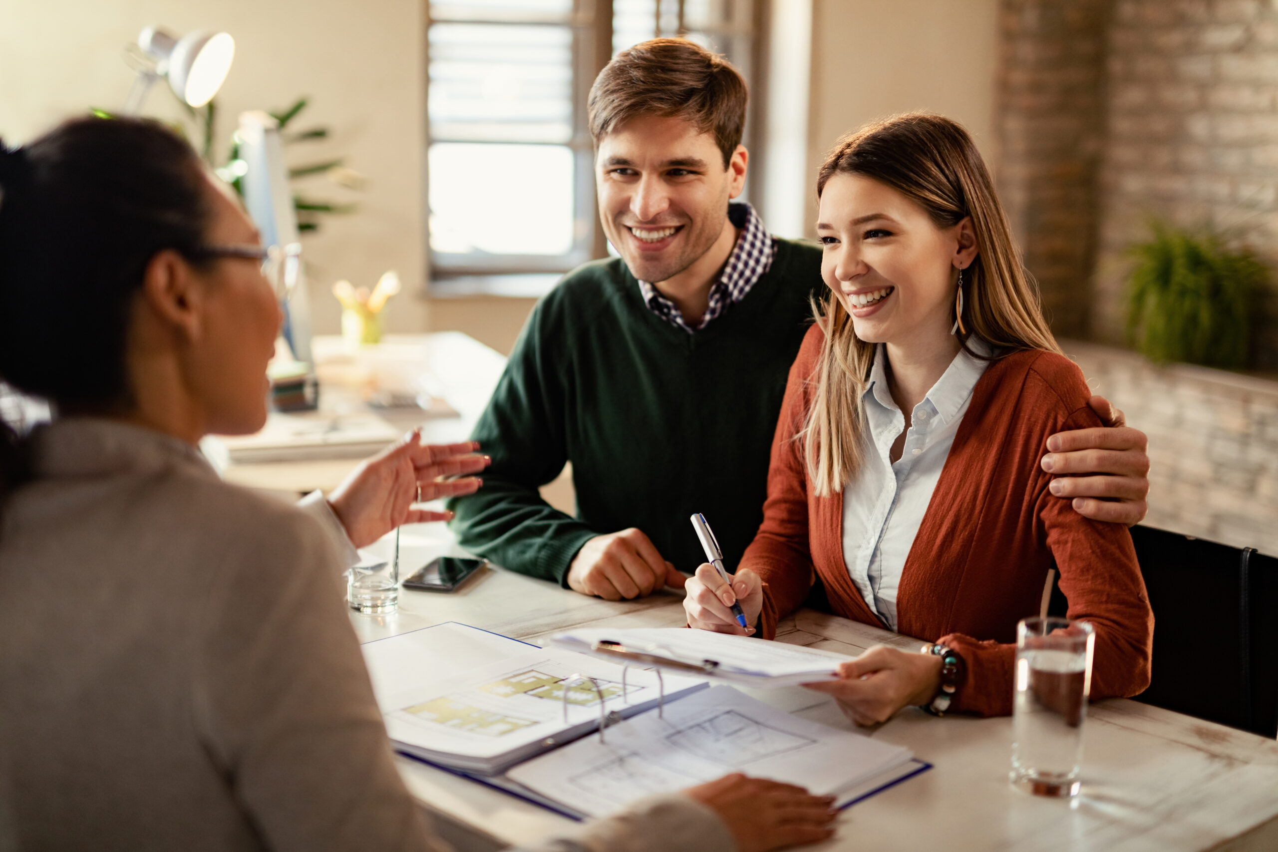 A financial advisor explaining Takaful insurance benefits to a couple in a professional setting